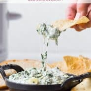 Spinach dip in a black dish, text overlay reads "crockpot spinach artichoke dip, rachelcooks.com"