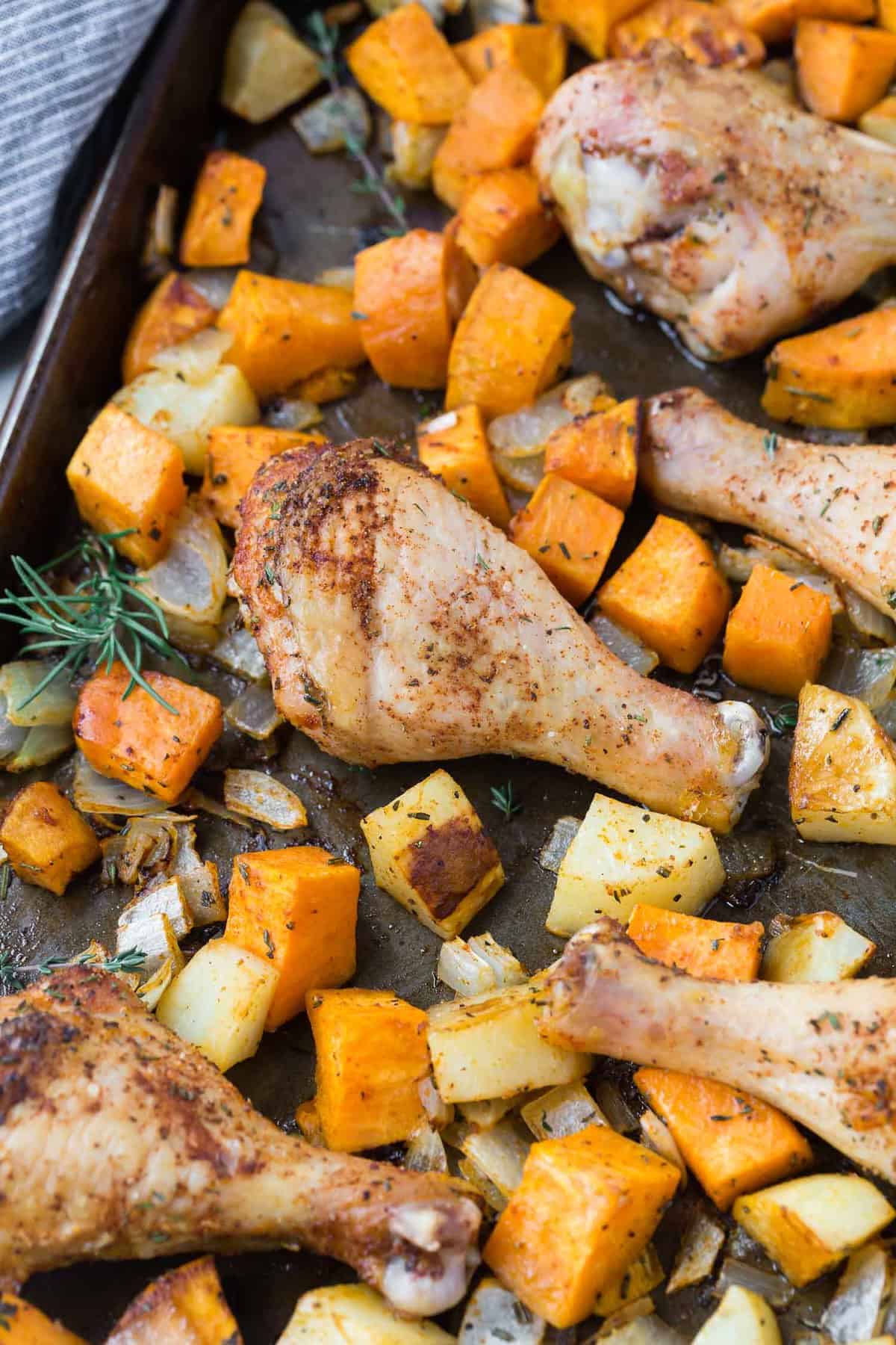 Roasted potatoes and drumsticks on a sheet pan.