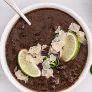 Overhead view of a bowl of soup, text overlay reads "instant pot black bean soup"