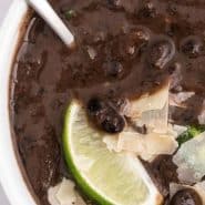 Overhead view of a bowl of soup, text overlay reads "instant pot black bean soup"