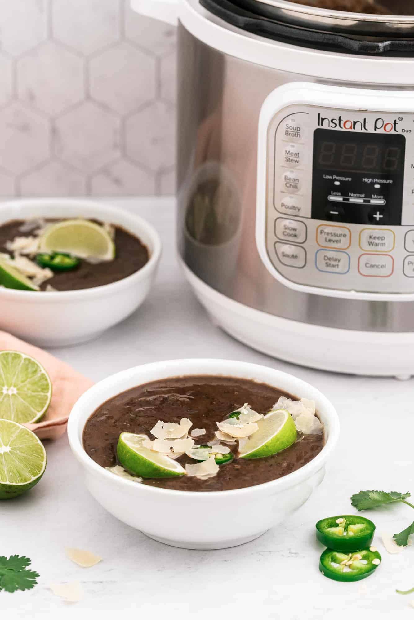 Two bowls of soup in front of an instant pot.