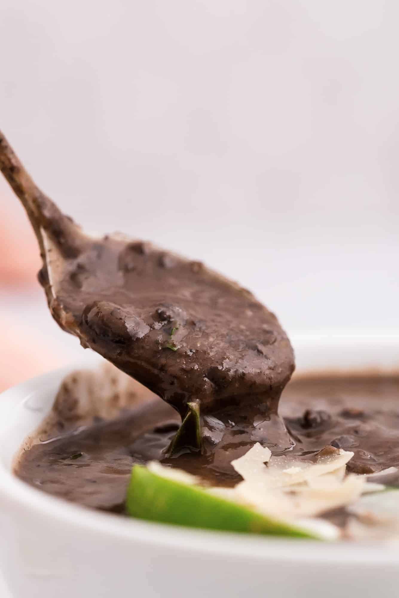 Black bean soup on a spoon, being pulled out of a bowl.