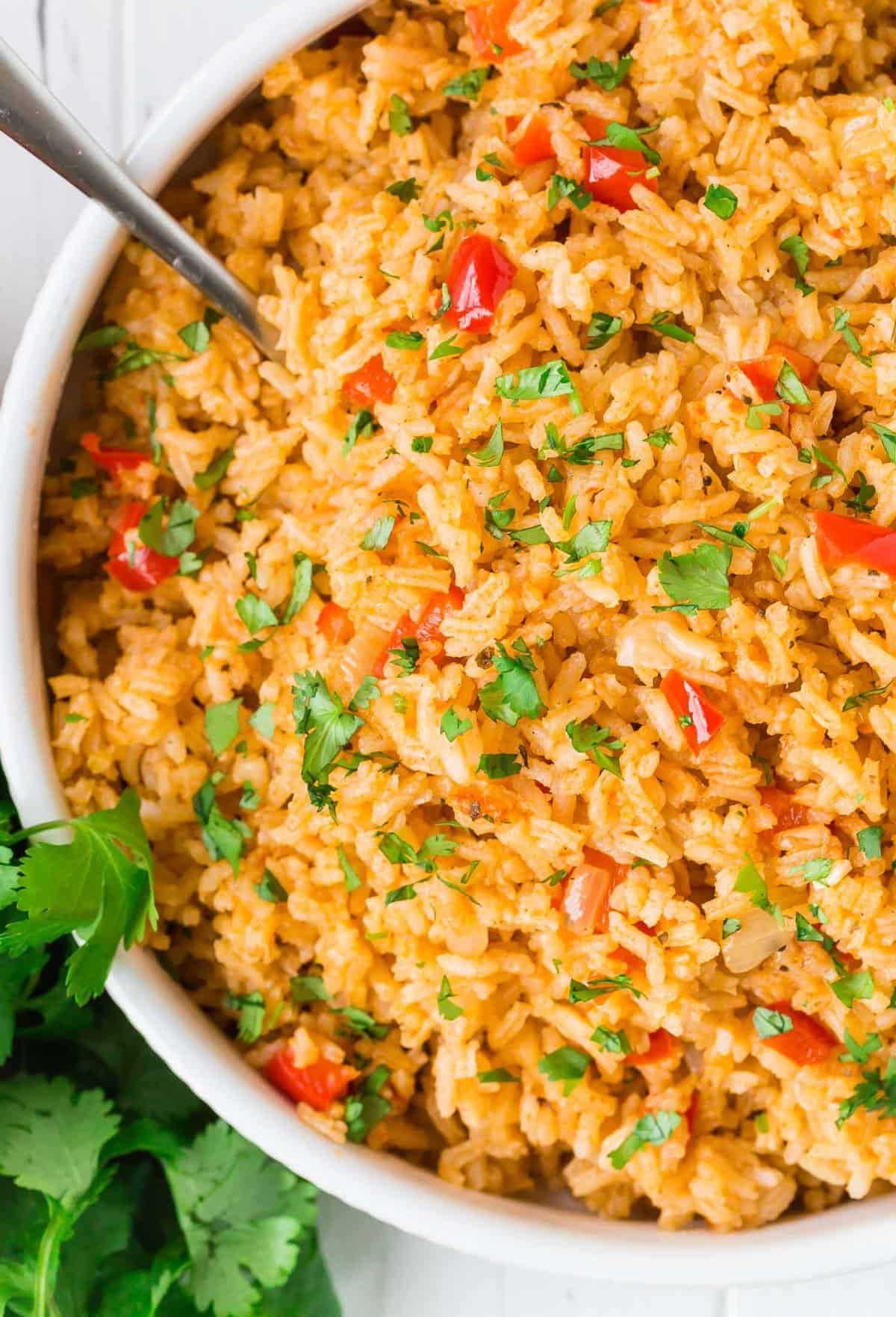 Overhead view of a large bowl of colorful rice garnished with fresh cilantro.