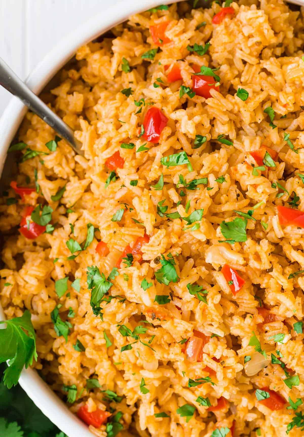 Close up of mexican rice in a white serving bowl.