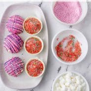 Overhead view of hot cocoa bombs being assembled, text overlay reads "pop rocks hot cocoa bombs, rachelcooks.com"