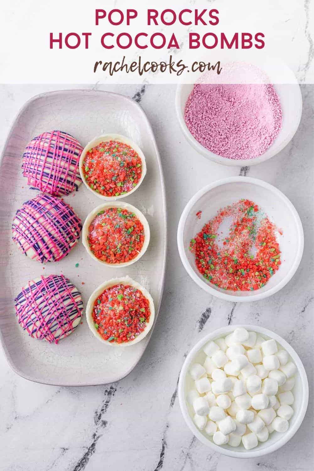 Overhead view of hot cocoa bombs being assembled, text overlay reads "pop rocks hot cocoa bombs, rachelcooks.com"