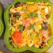 A stuffed pepper in a pan, text overlay reads "southwestern stuffed bell peppers with quinoa, rachelcooks.com"