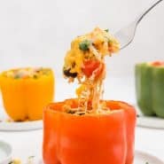 A stuffed pepper on a white plate, text overlay reads "southwestern stuffed bell peppers with quinoa, rachelcooks.com"