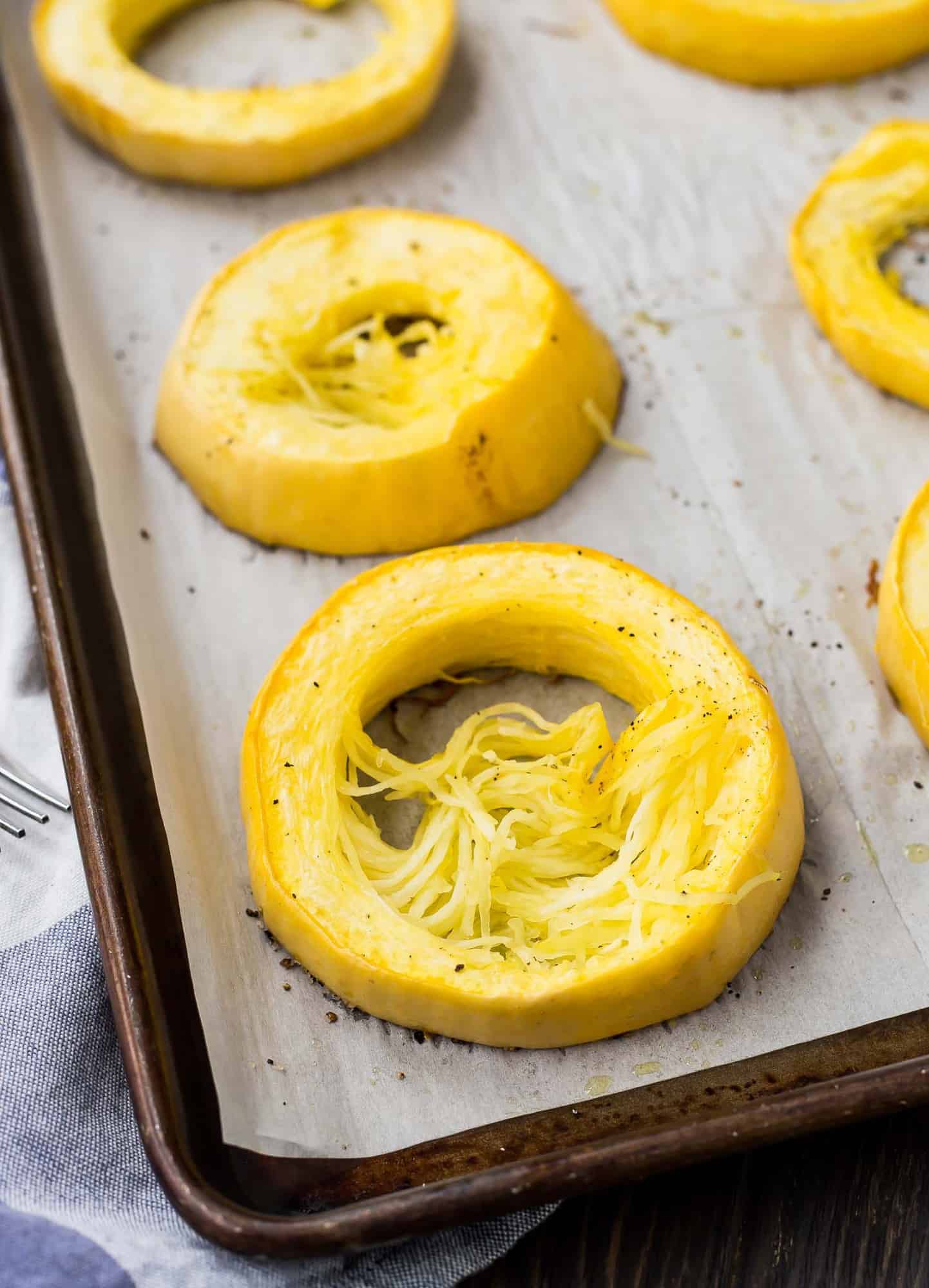 Baked squash rings on a baking sheet with parchment paper.