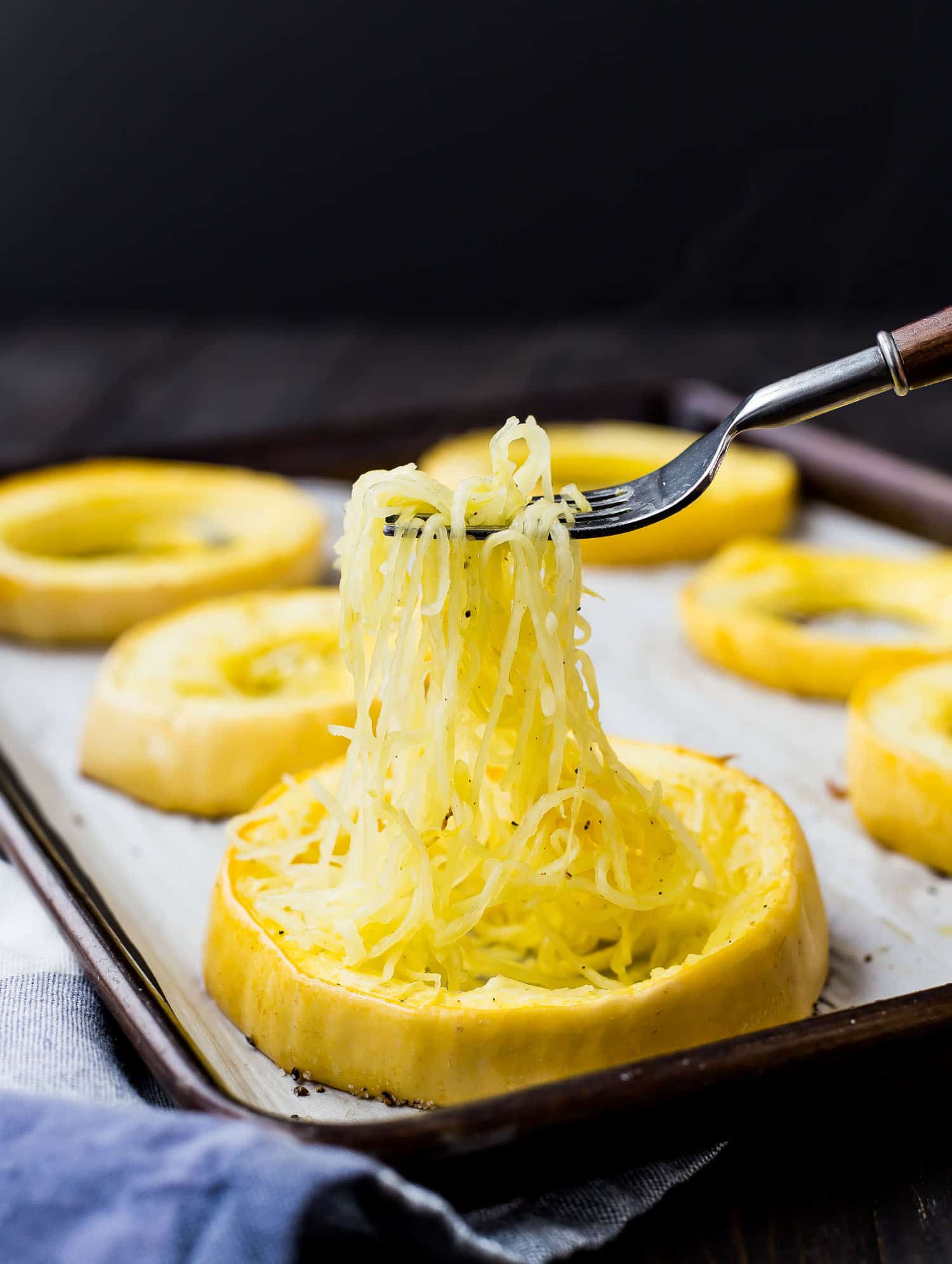 Ring of spaghetti squash, strands being pulled out with a fork.