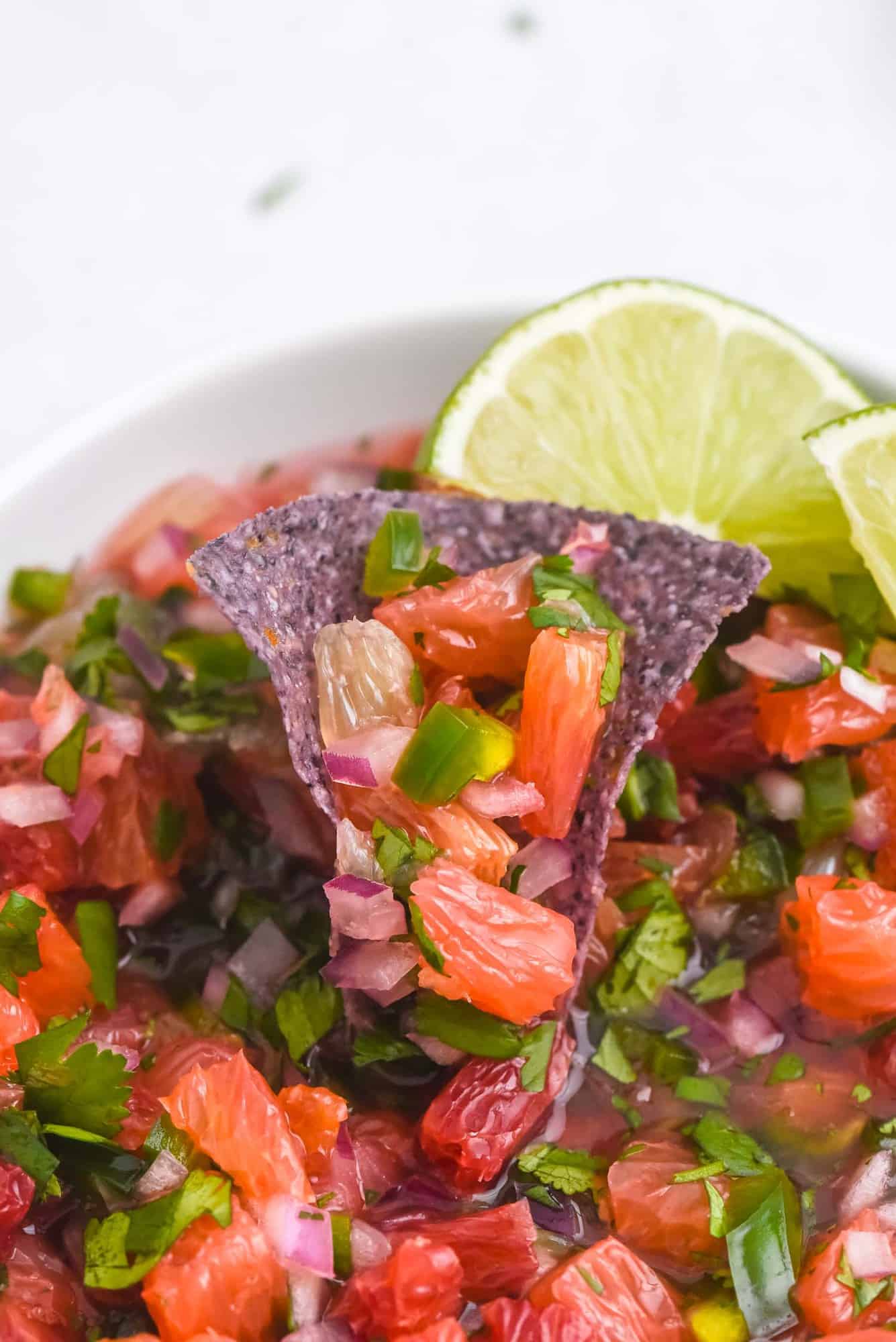 Salsa made with grapefuit and oranges, on a blue corn chip.