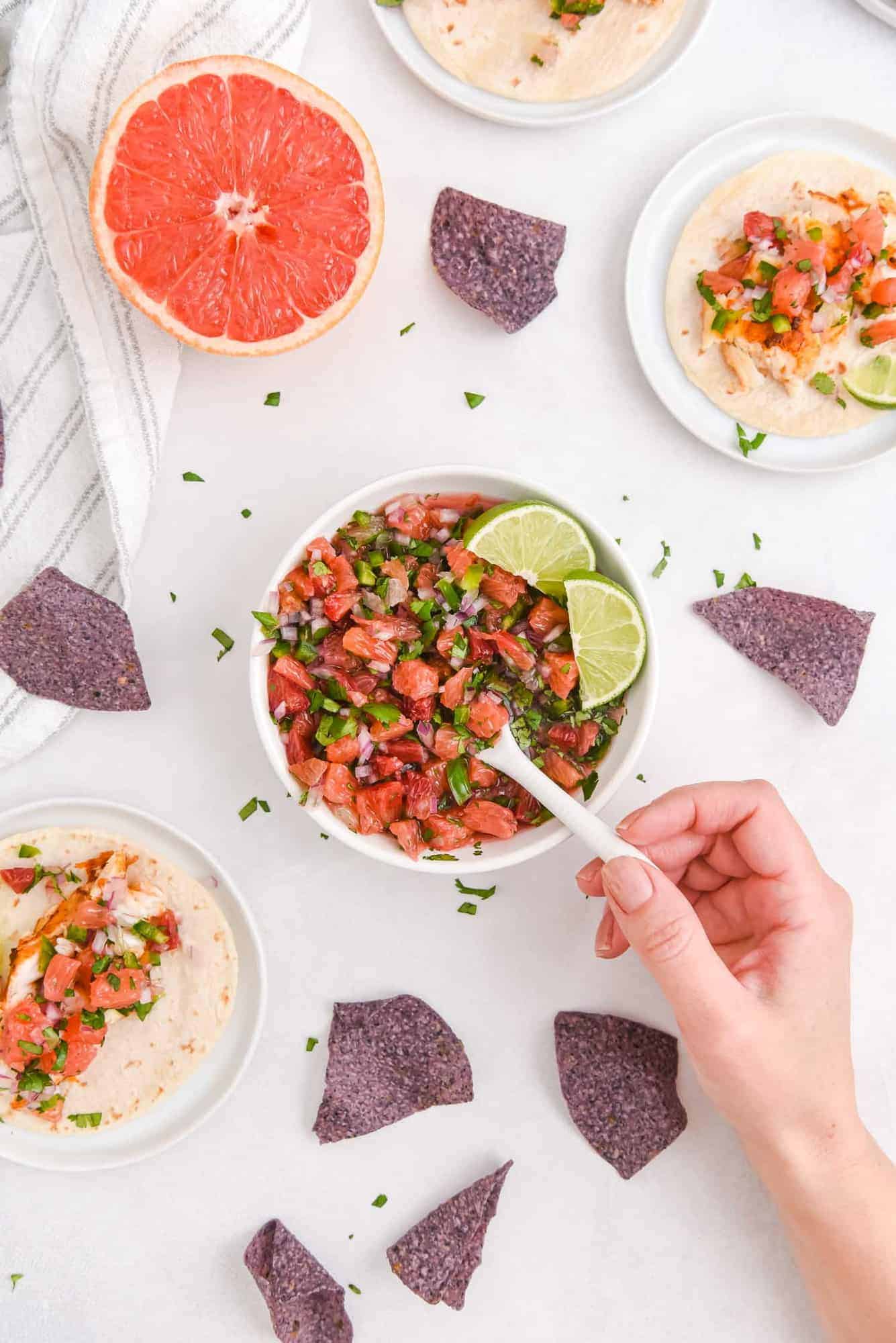 Salsa being scooped out of a bowl on a spoon.