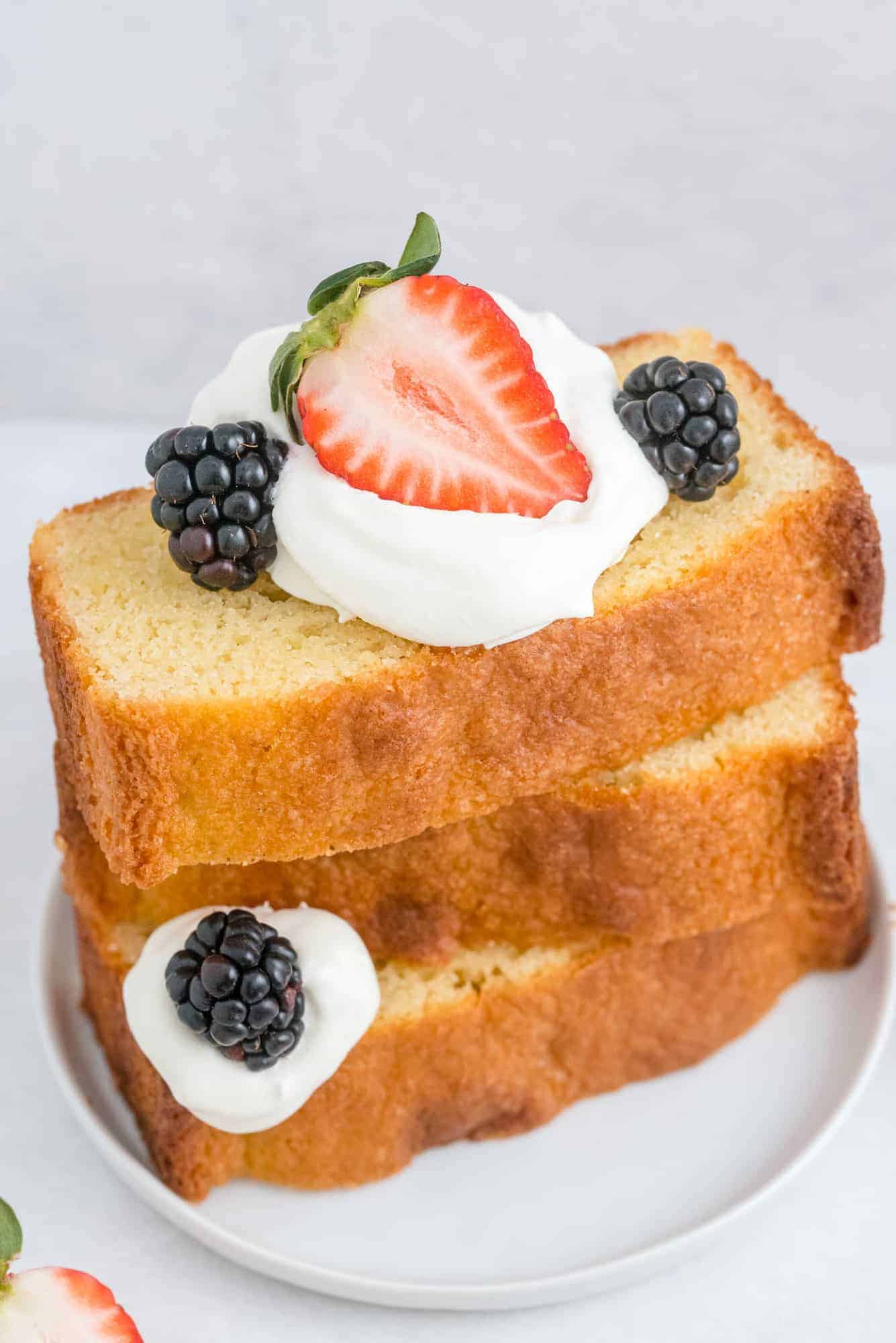 Pound cake slices stacked with fruit and berries.