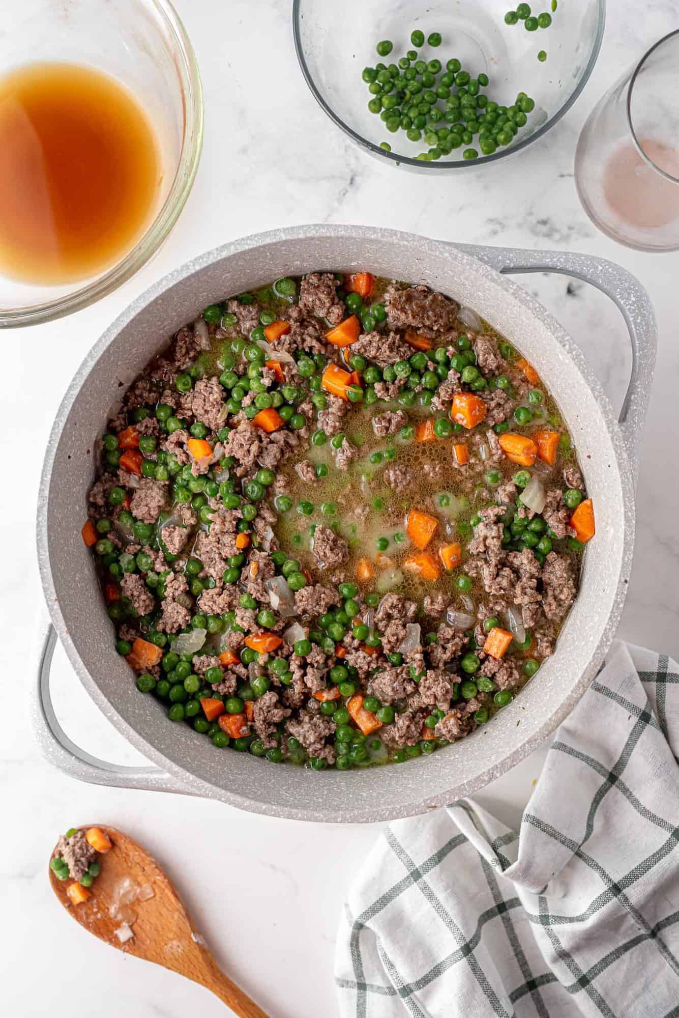 Ground meat, vegetables, and gravy in a pan.