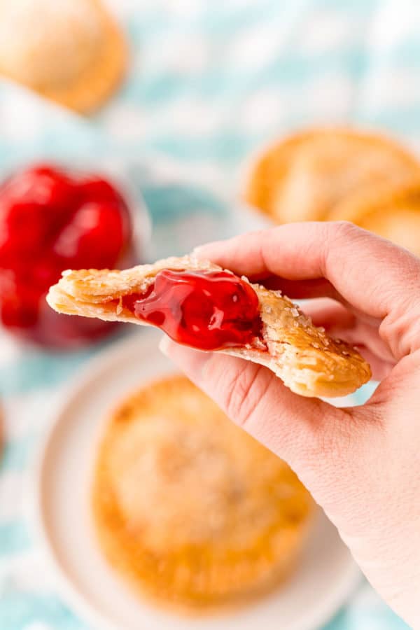 Half eaten cherry hand pie in a hand.