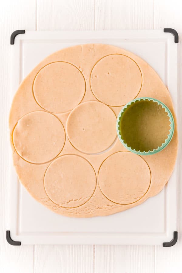 Biscuit cutter cutting a pie crust into circles.