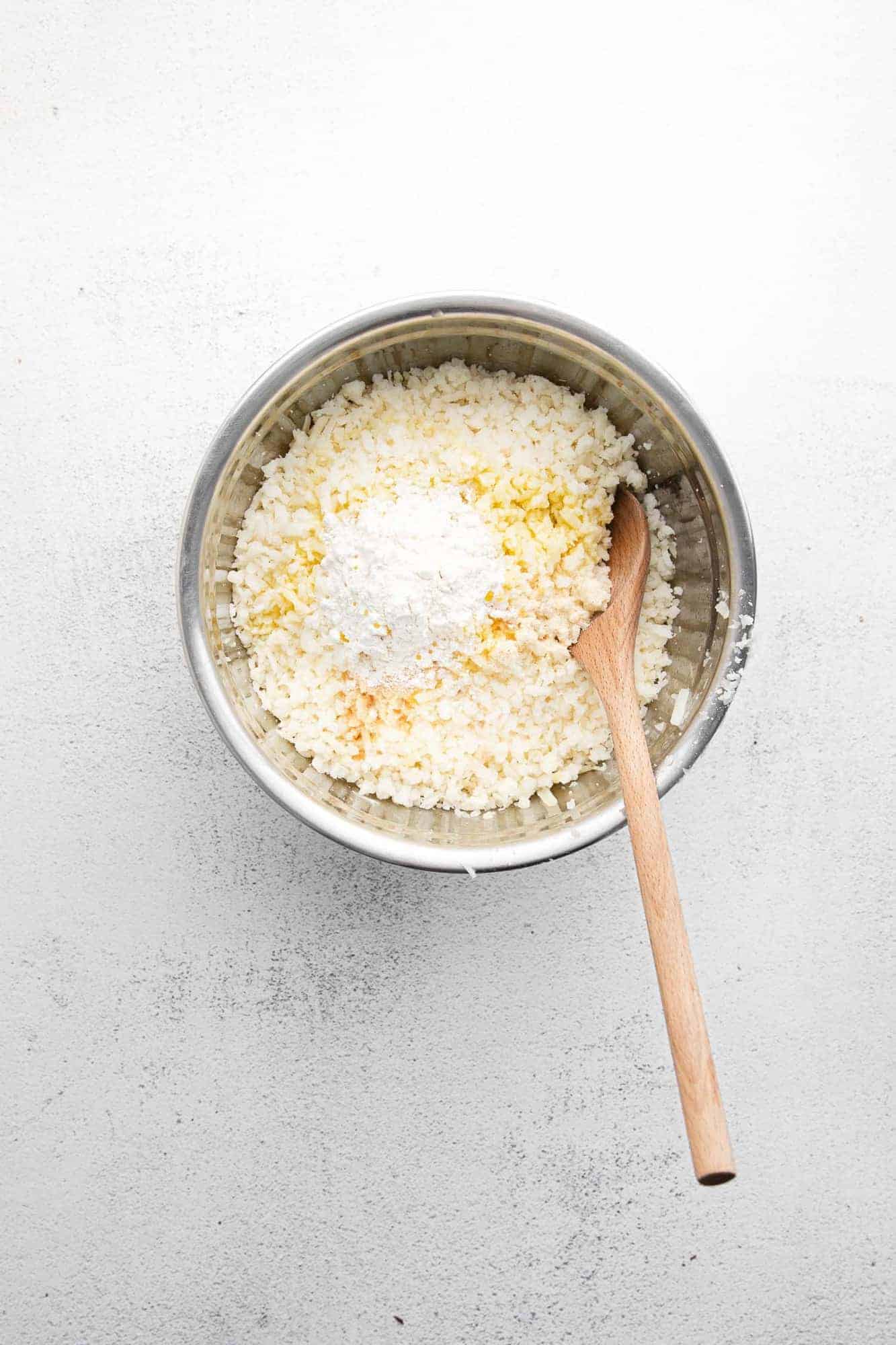 Uncooked hashbrowns in a mixing bowl.