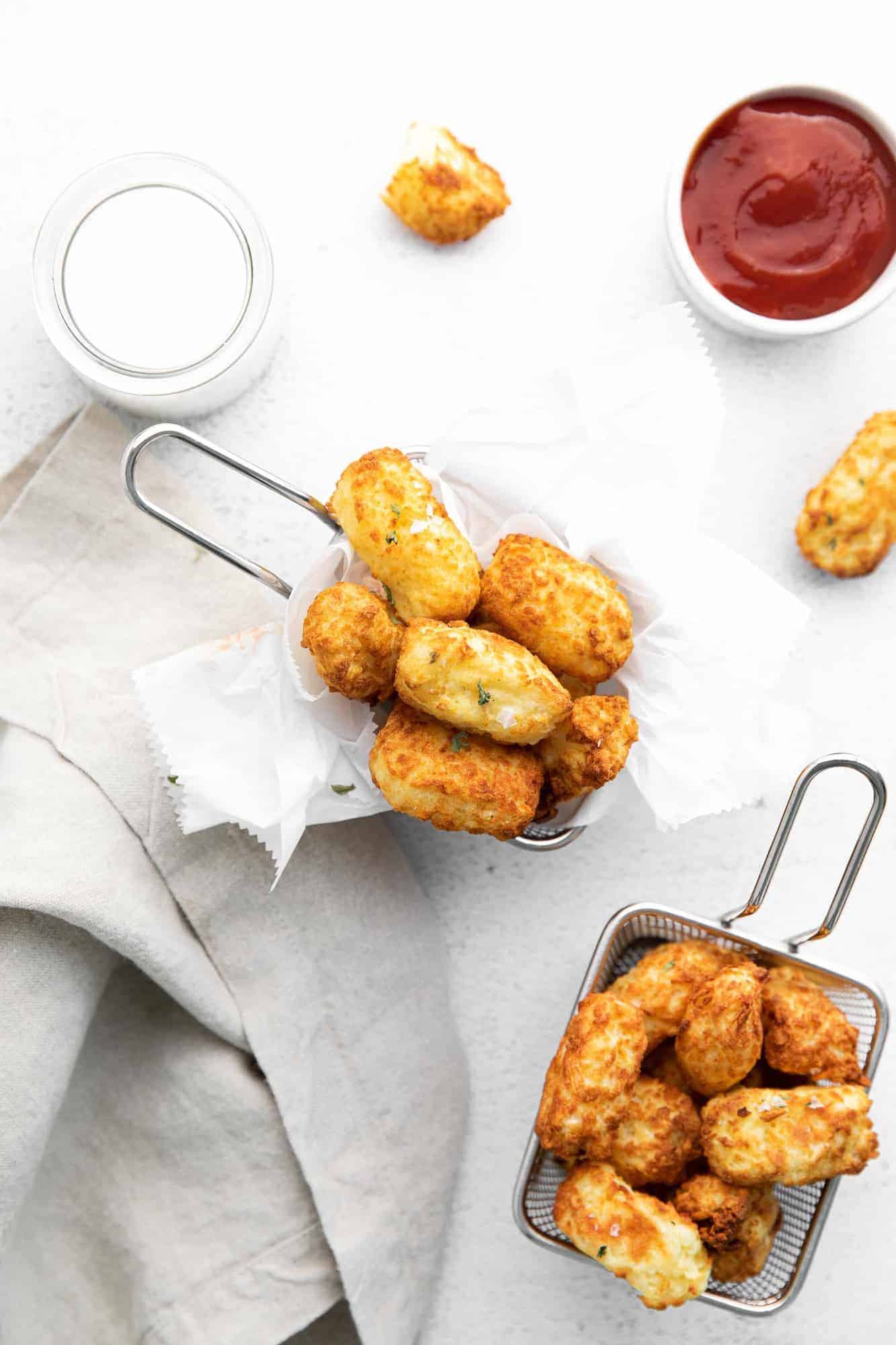 Overhead view: small baskets of tots, ketchup.