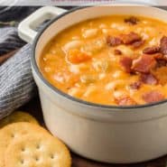 Soup in a white two-handled bowl, text overlay reads "homemade bean and bacon soup, rachelcooks.com"