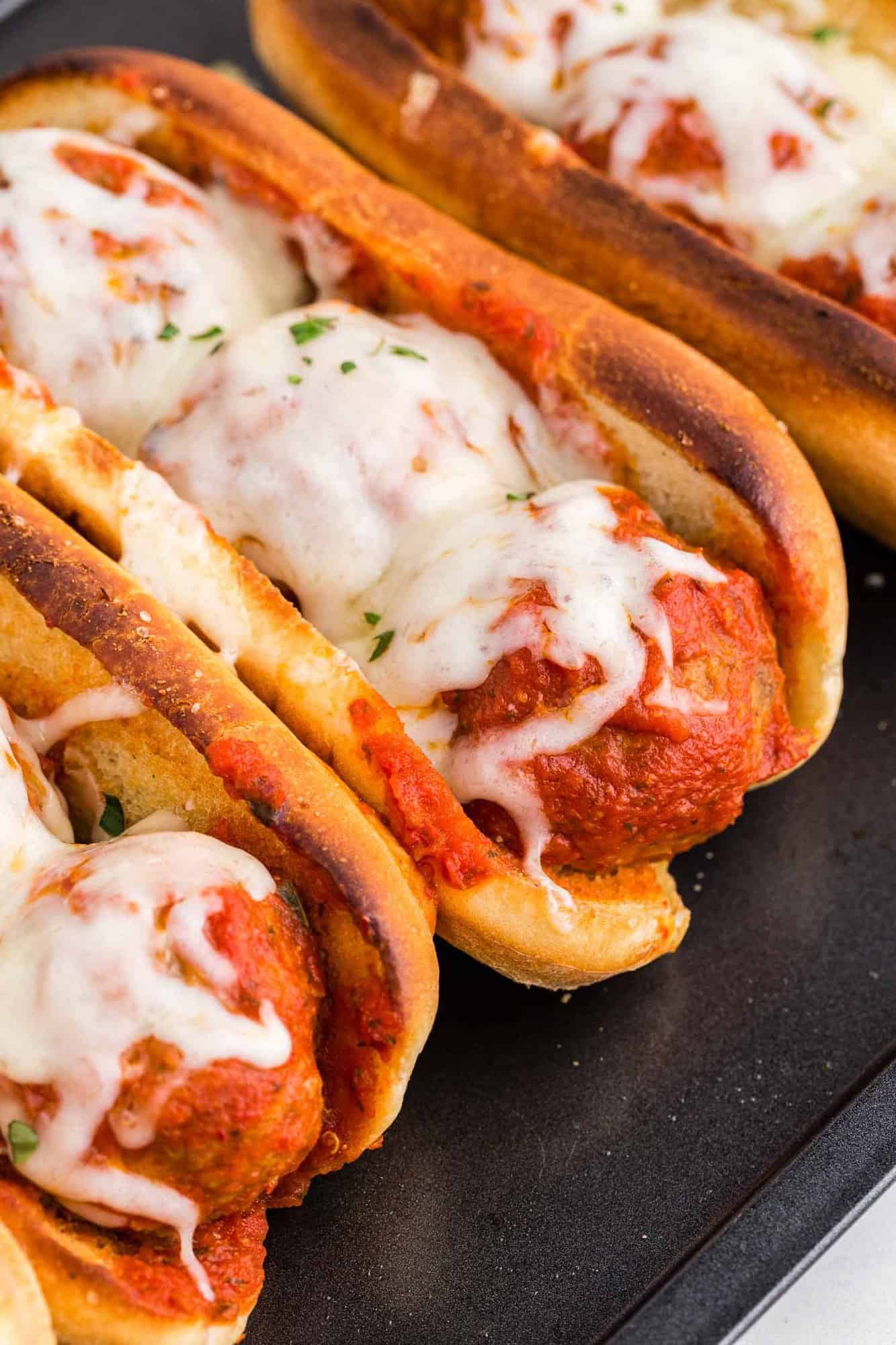 Multiple meatball subs on a platter.