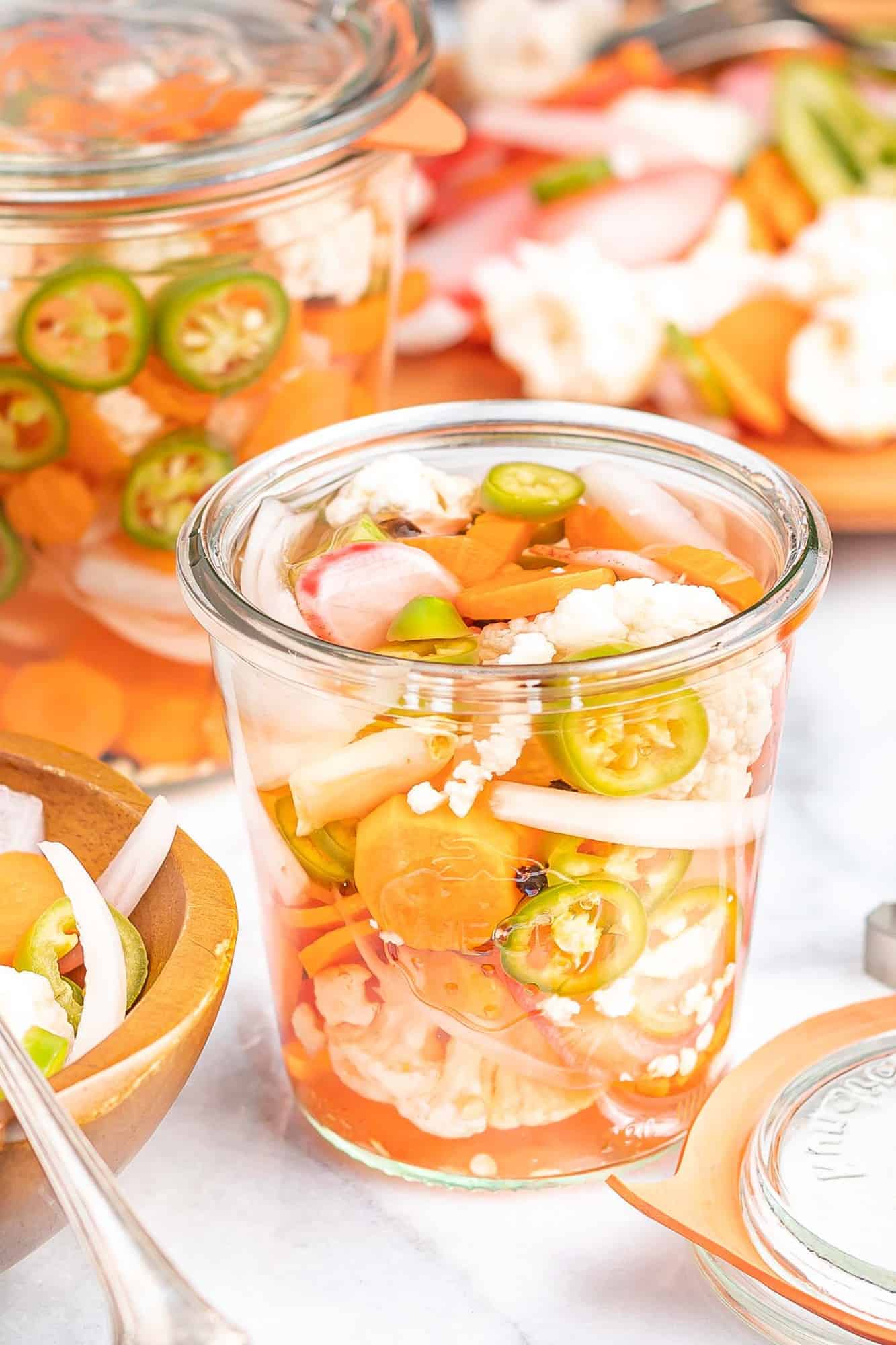 Mixed vegetables in a glass jar with liquid.