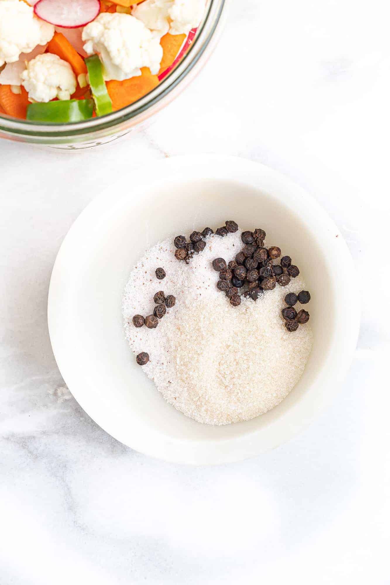 Sugar, salt, and peppercorns in a small bowl.