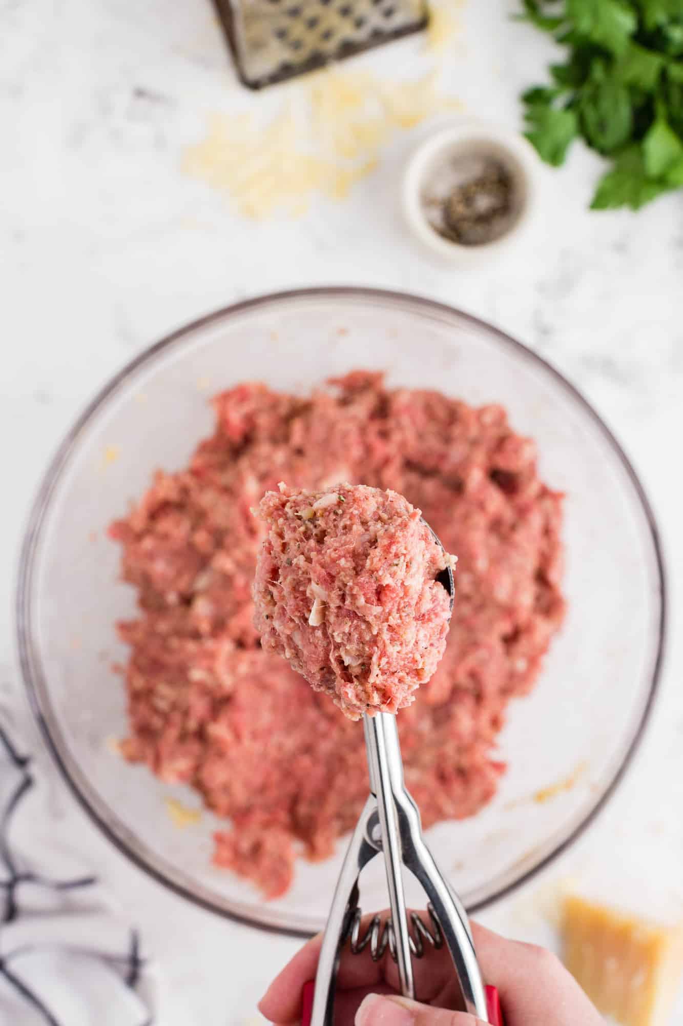 Uncooked ground meat in a scoop.