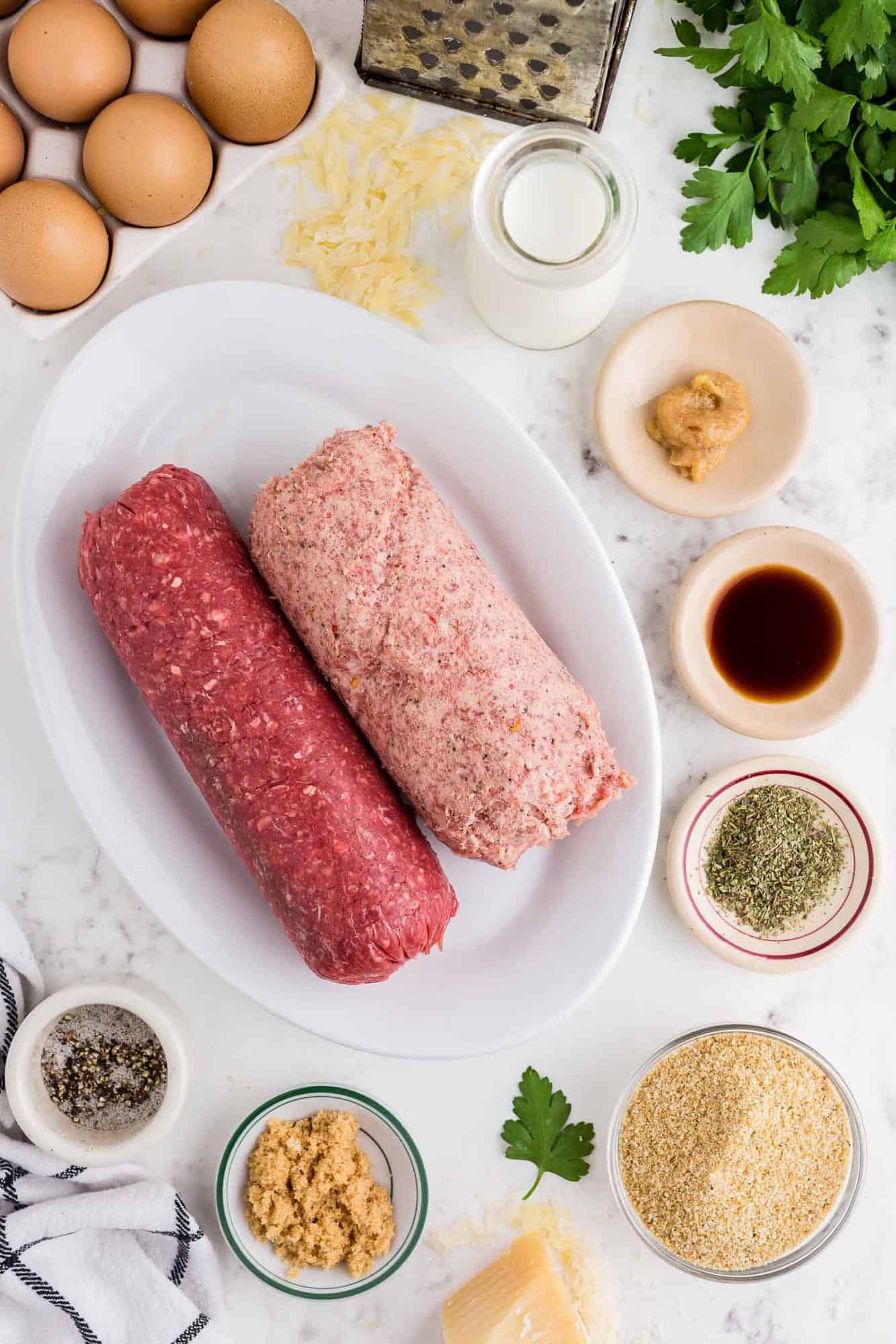 Overhead view of ingredients, ground meat, spices, eggs, and more.