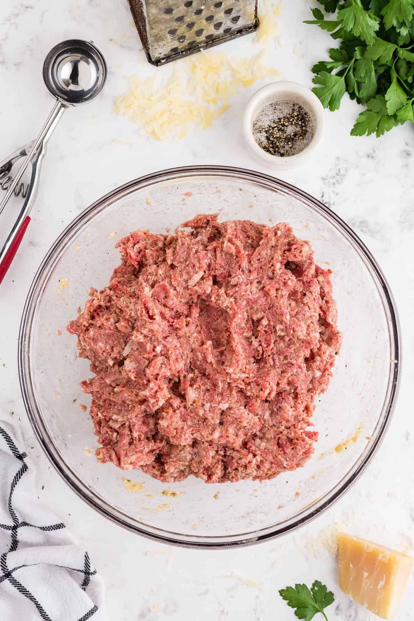 Ground meat and spices in a bowl, mixed together.