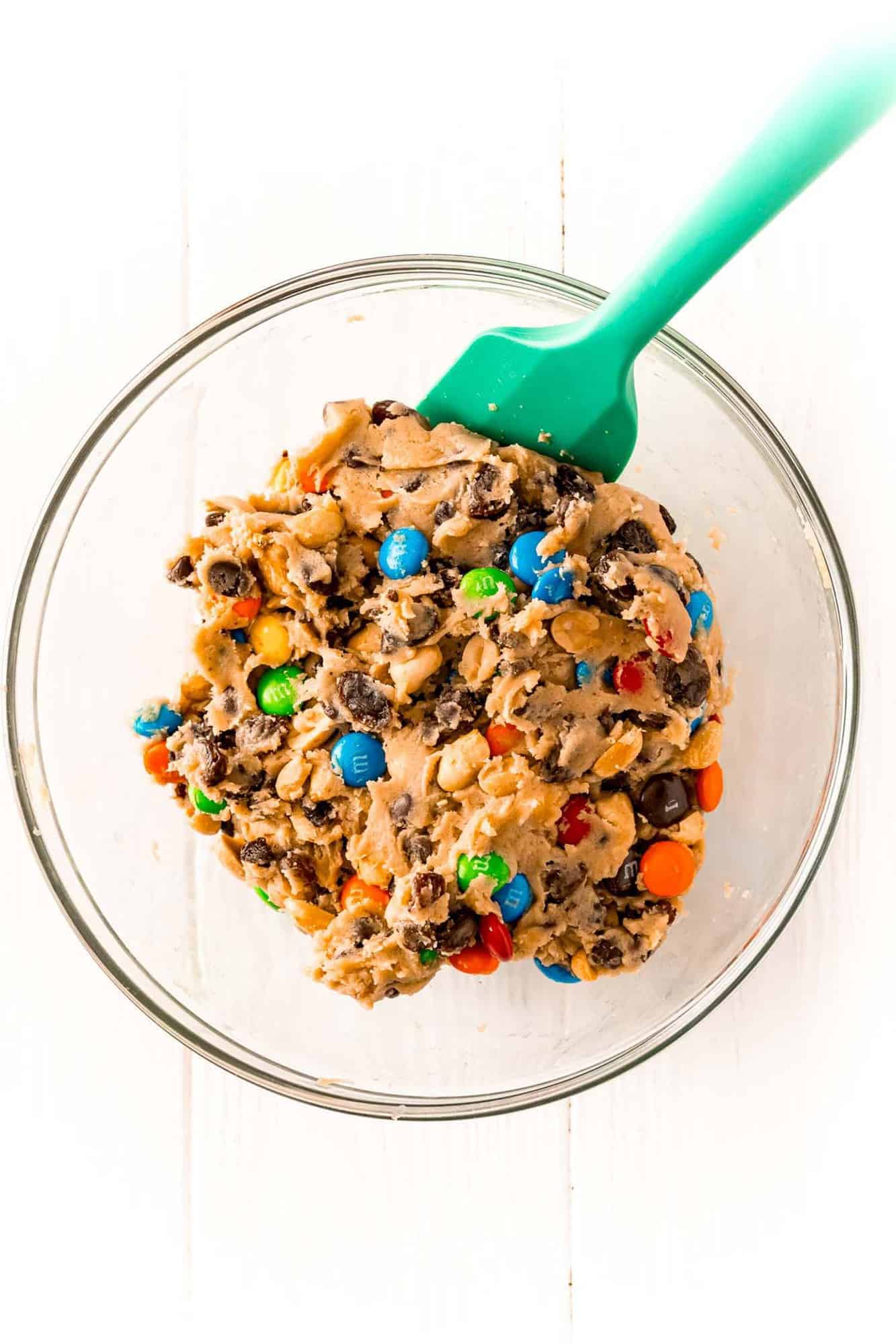 Mixed cookie dough in a glass mixing bowl.