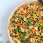 Overhead view of fried rice topped with sliced green onions.