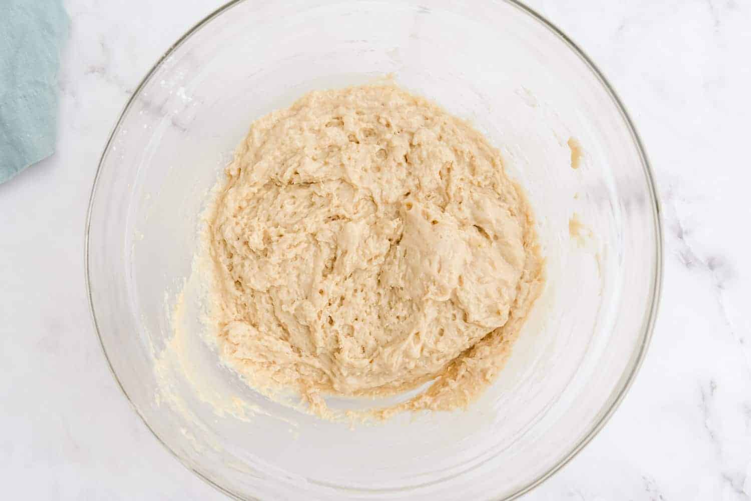 Bread batter in a glass bowl.