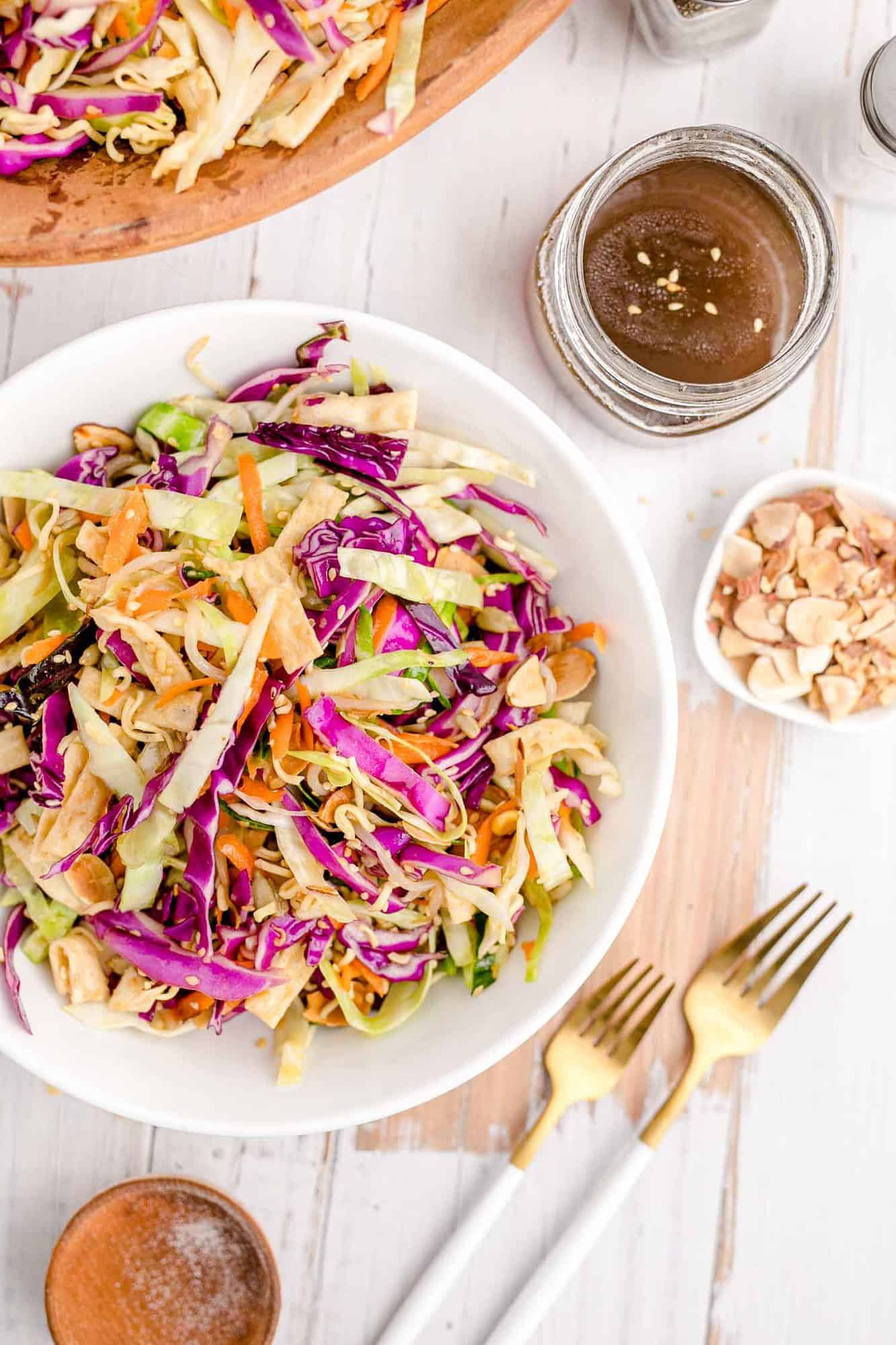 Overhead view of a cabbage based Asian style salad in a white bowl.