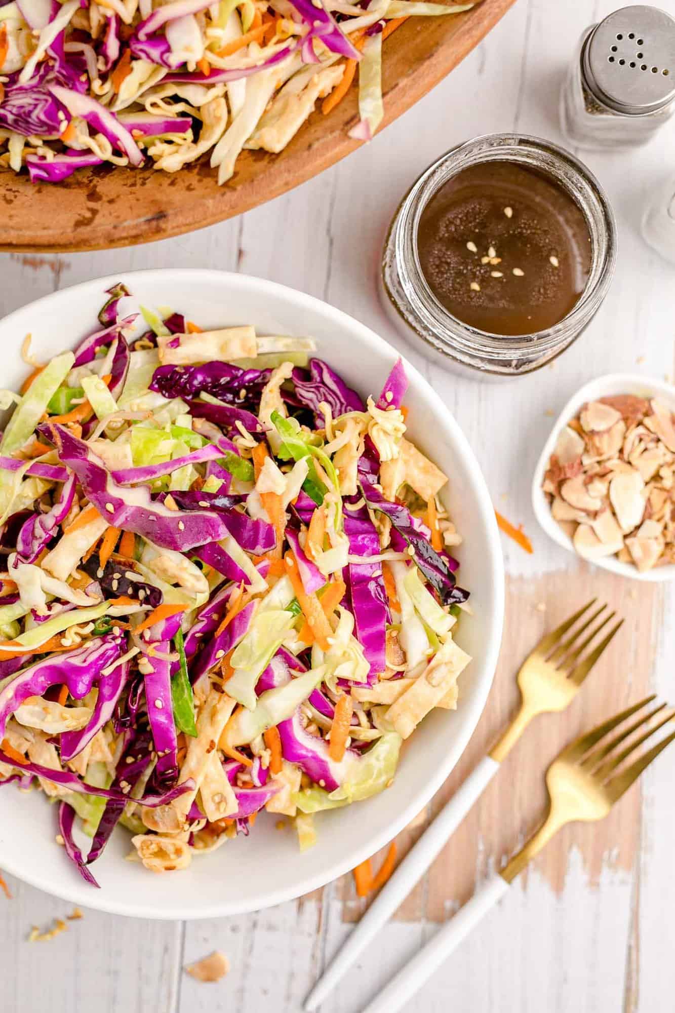 Salad in a white bowl with two forks nearby.