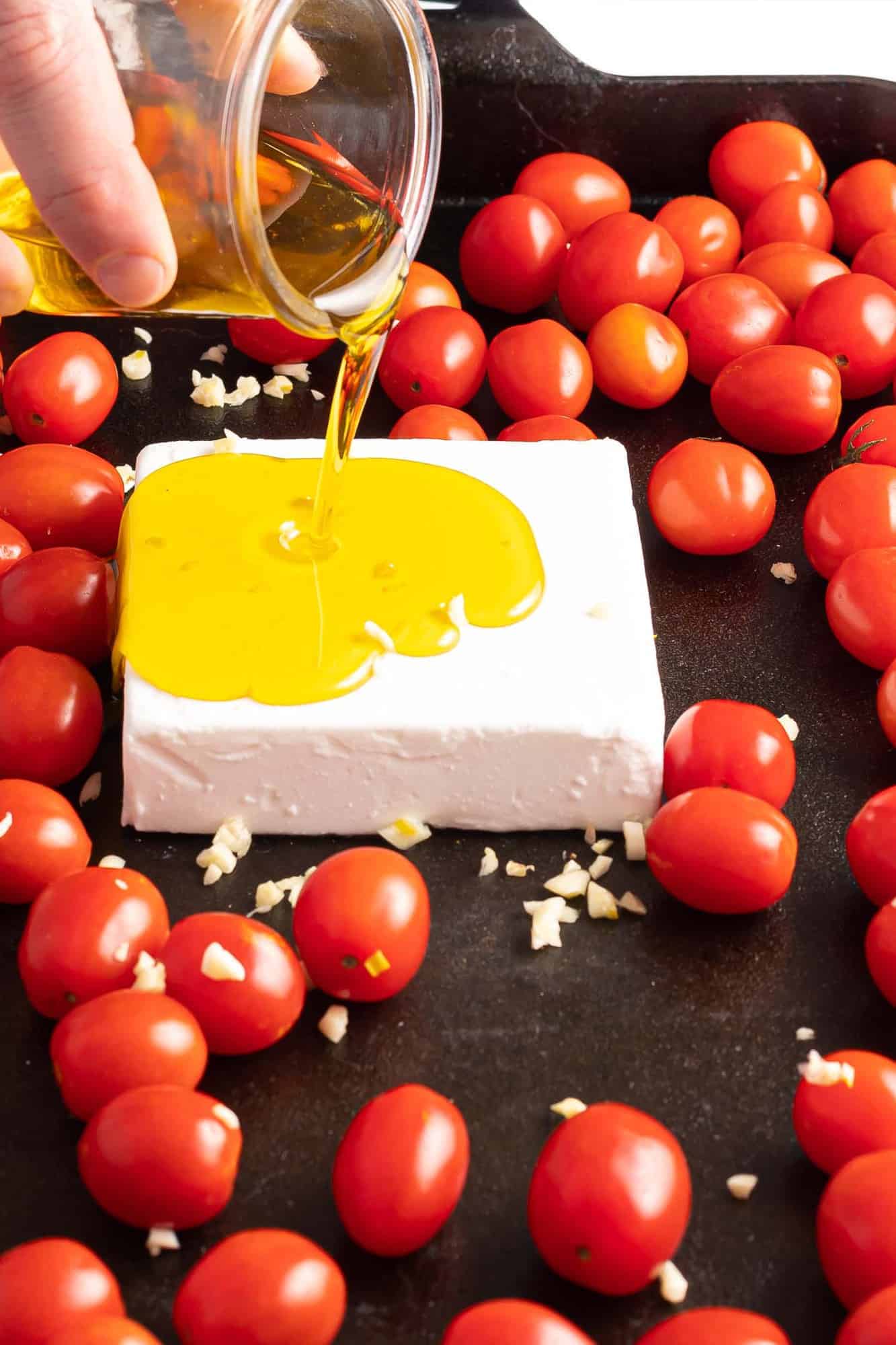 Olive oil being poured on a block of feta.