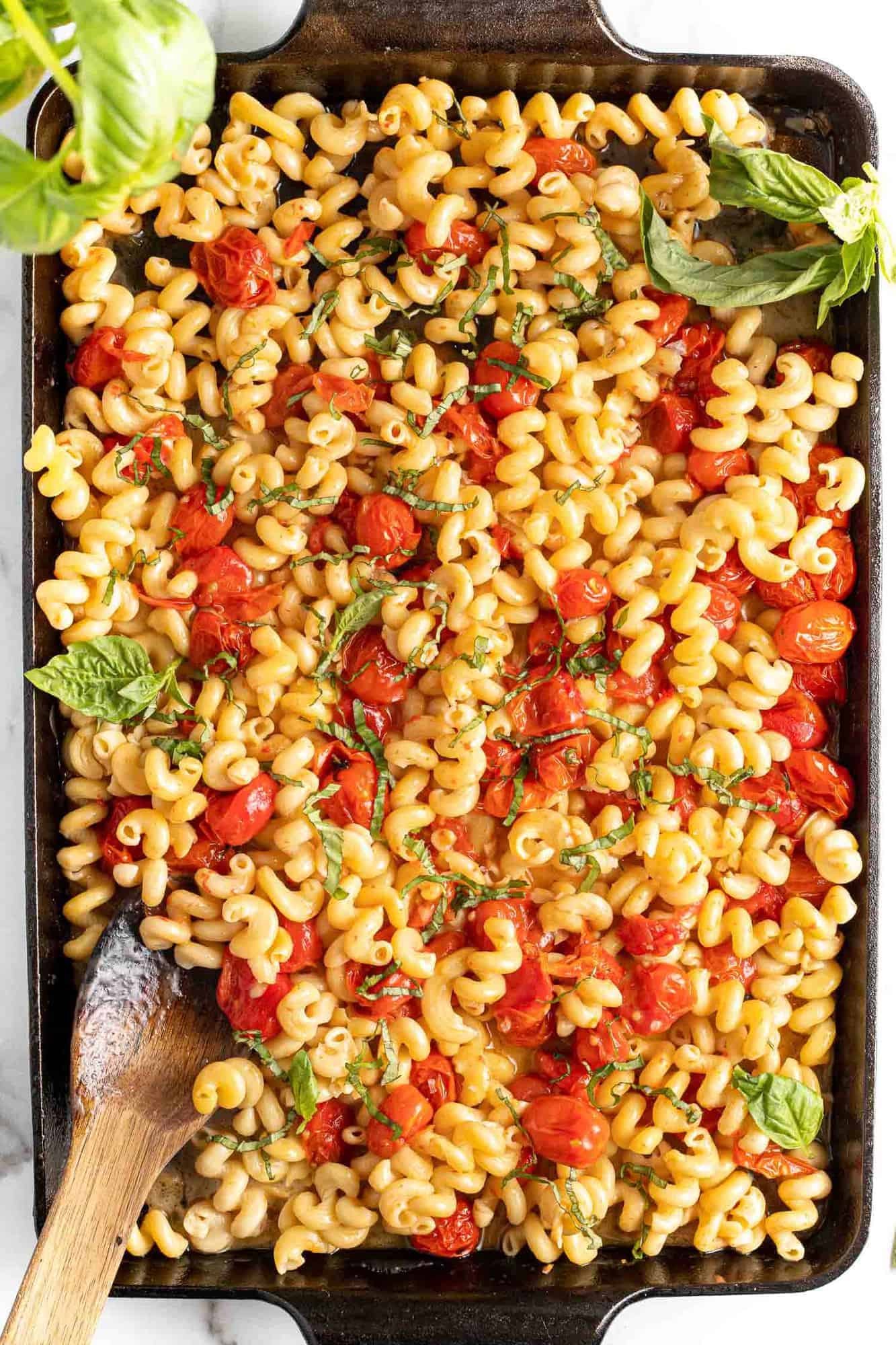 Pasta and tomatoes in a feta sauce, sprinkled with fresh basil.