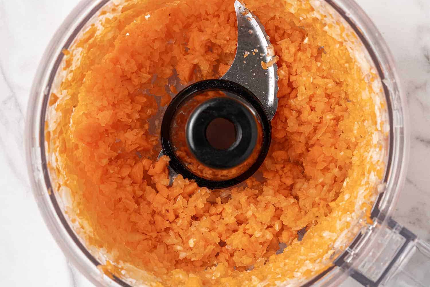 Chopped up carrots and onions in a food processor.