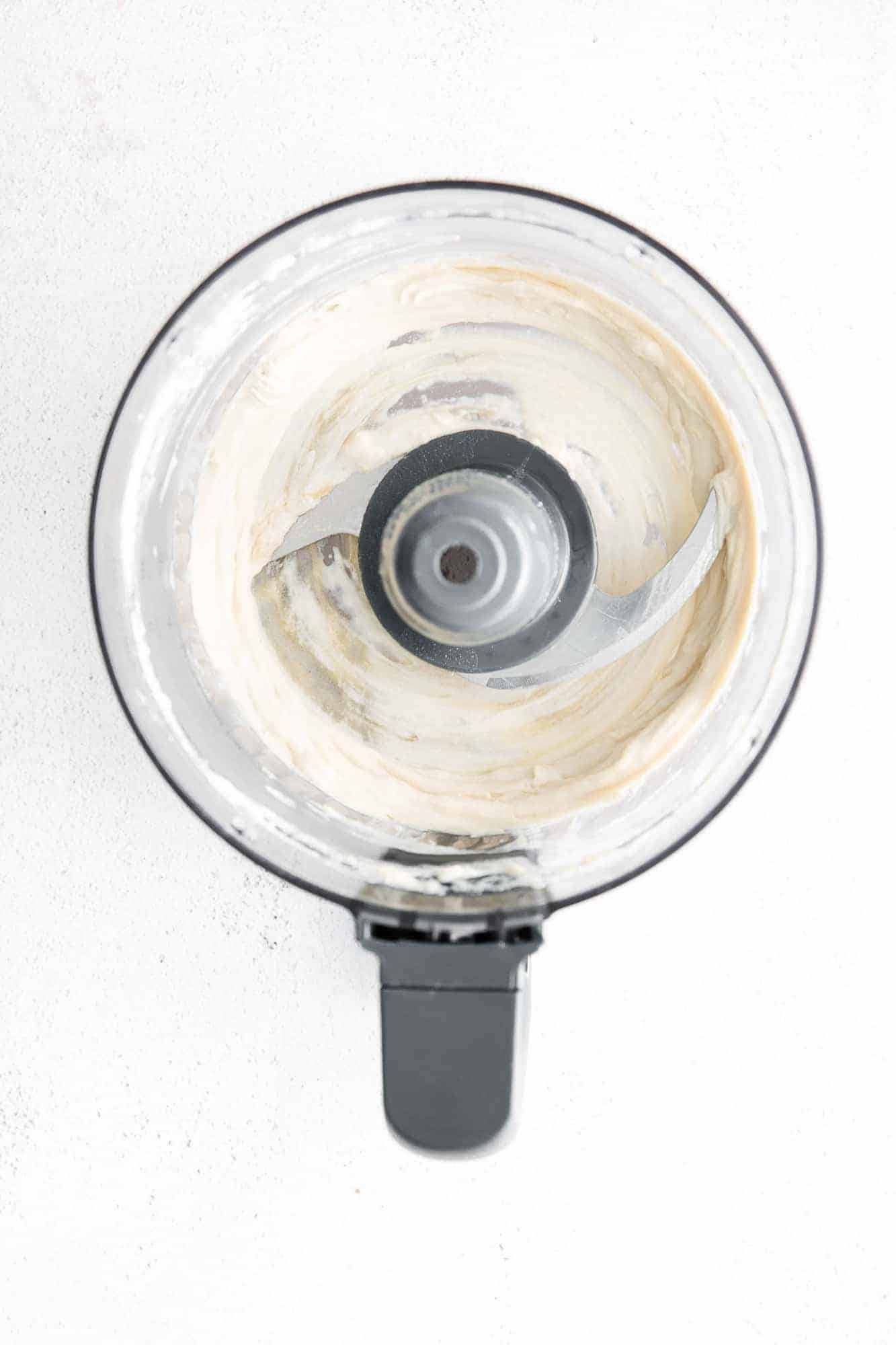 Overhead view of tahini in a food processor.