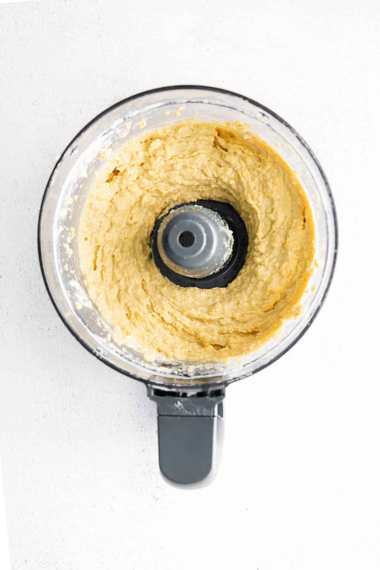 Overhead view of hummus in a food processor.