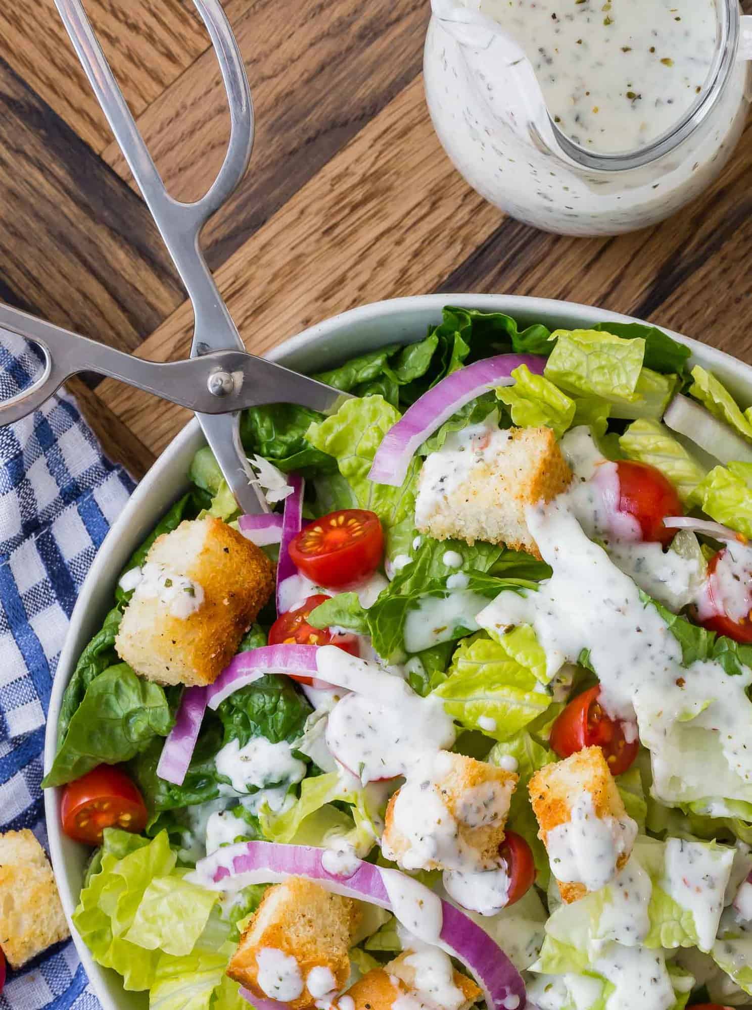 Dressing on a tossed green salad, and in a small glass pitcher.