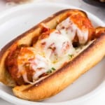 Sub bun filled with meatballs, red sauce, and melted mozzarella cheese.