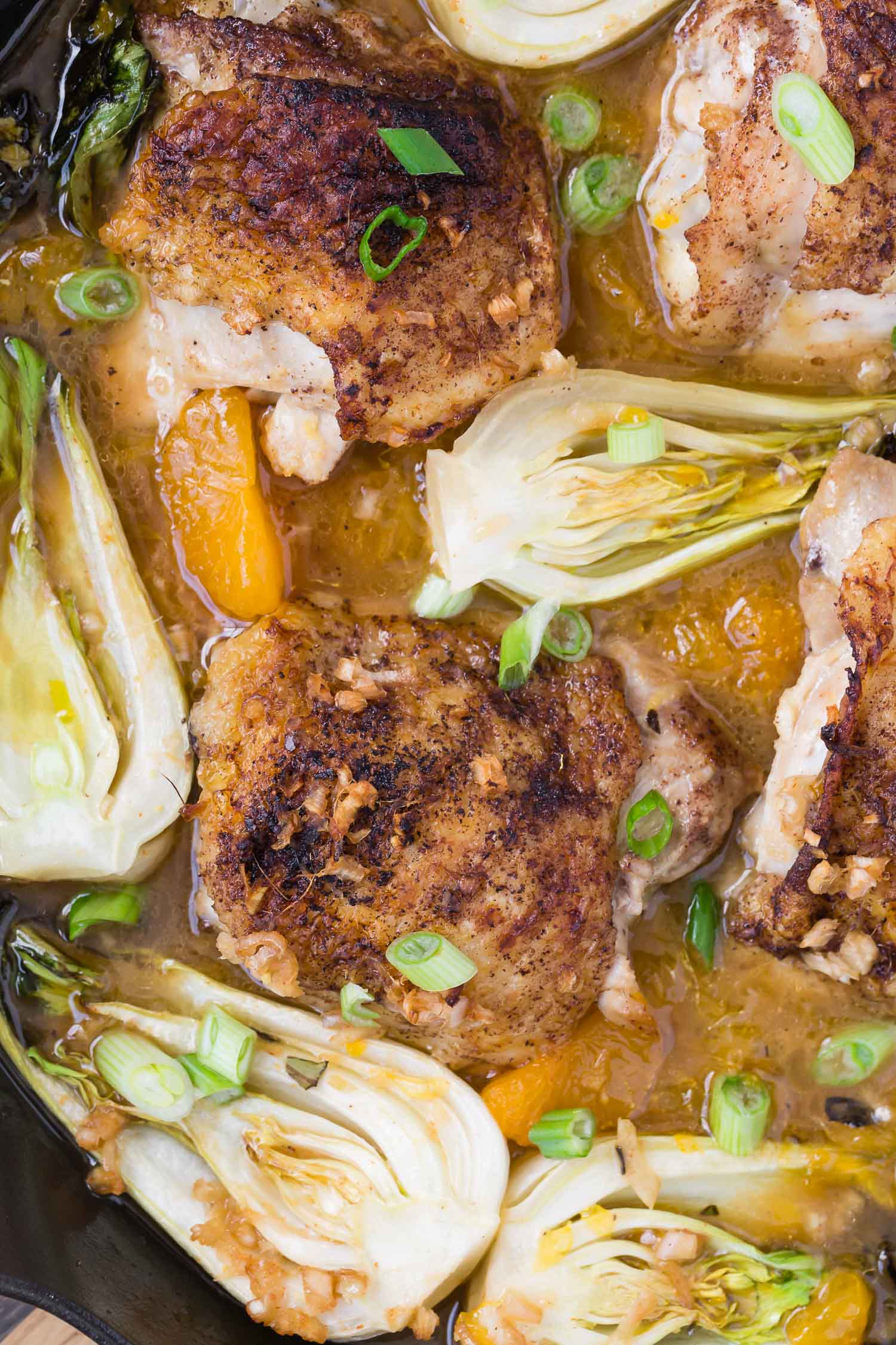 Close up of chicken and bok choy in a pan.