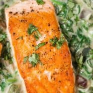 Overhead view of seared salmon, text overlay reads "salmon with spinach poblano cream sauce."