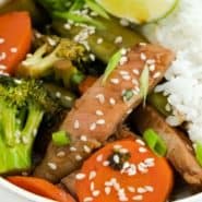 Beef and vegetables in a bowl, text overlay reads "easy sesame beef - perfect weeknight meal! rachelcooks.com"