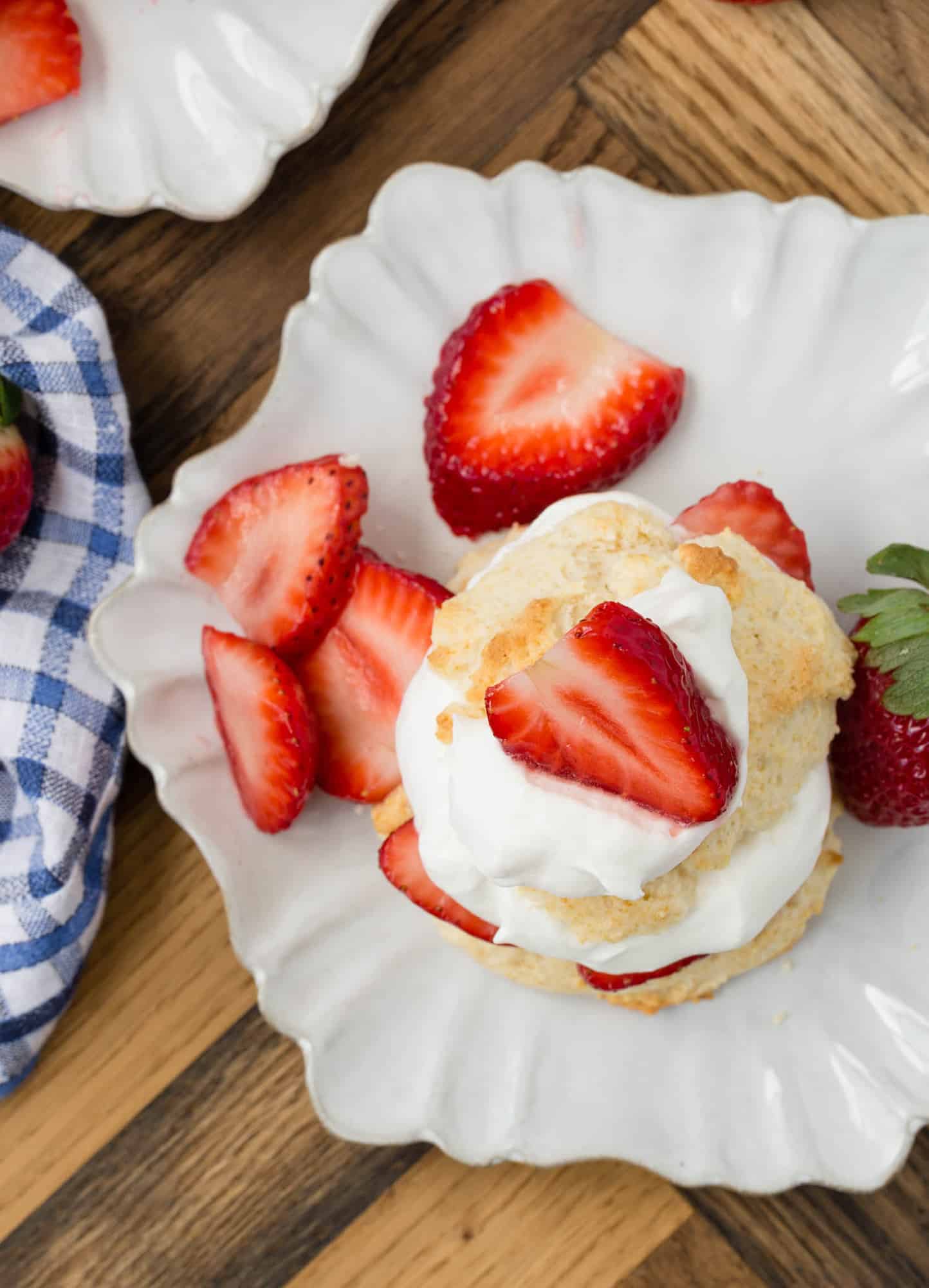 Overhead view of strawberry shortcake on a white plate.