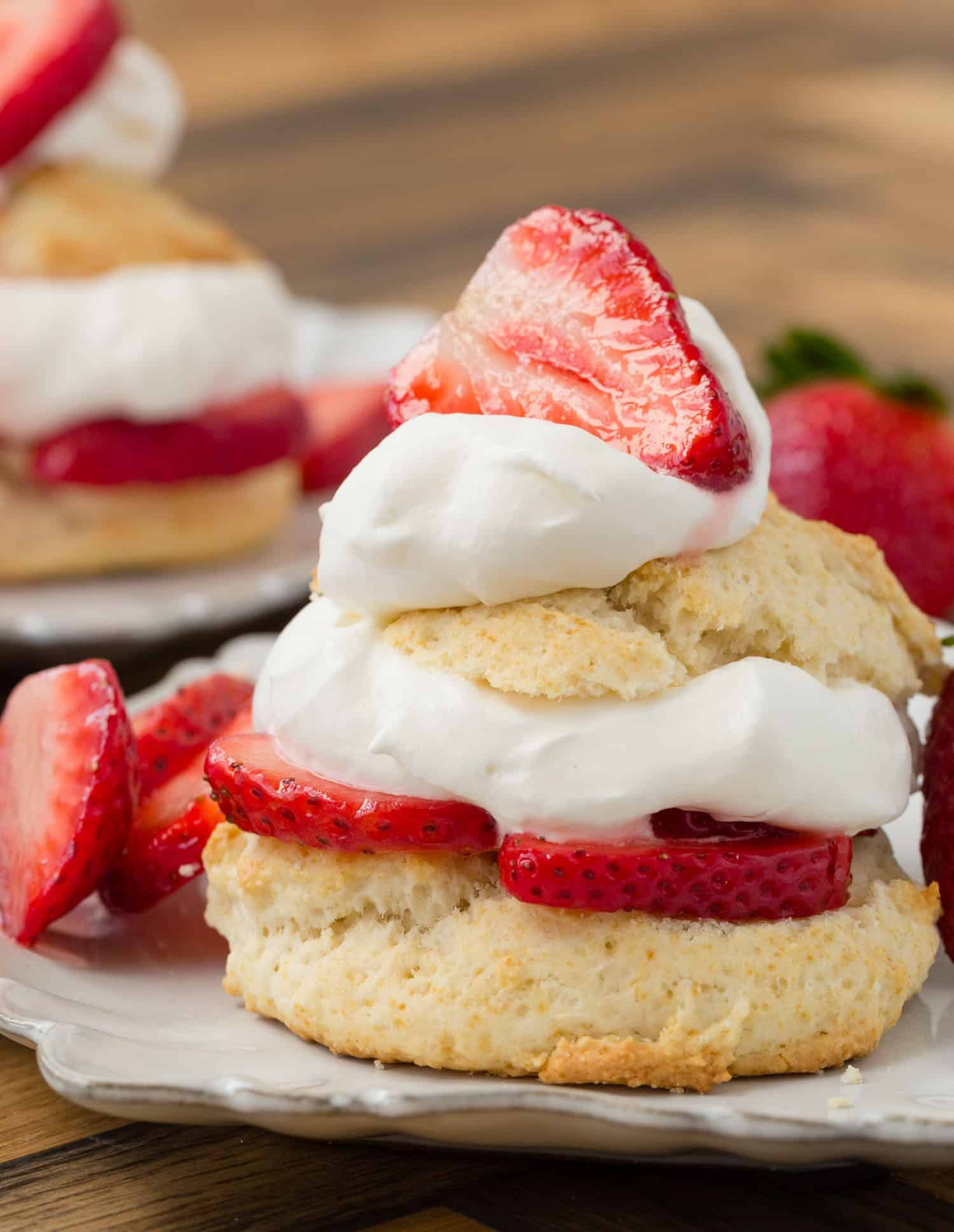 Close up view of strawberry shortcake on a white plate.