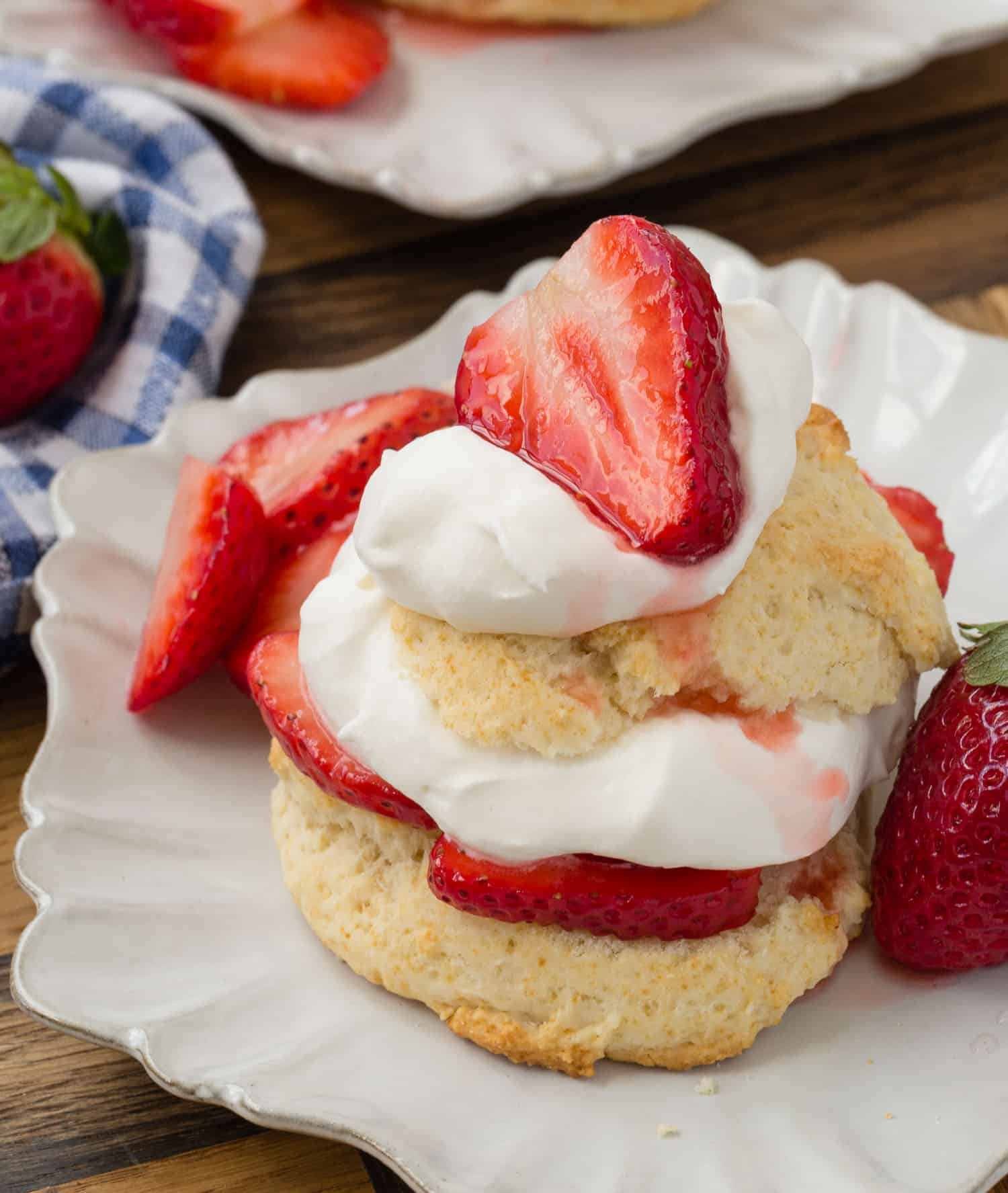 A shortcake split in half and filled with whipped cream and strawberries.