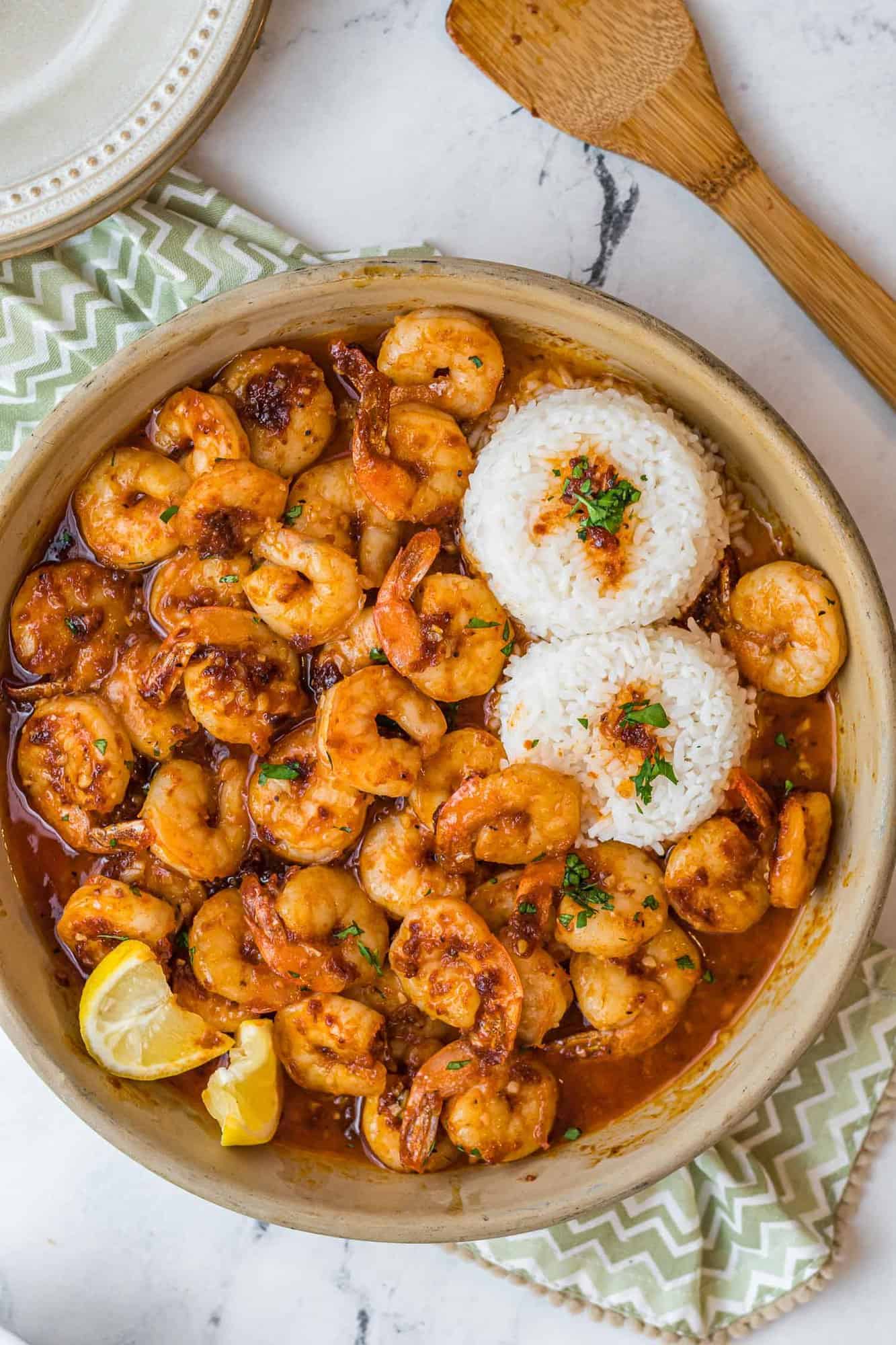 Overhead view of shrimp, rice, and a reddish brown sauce.