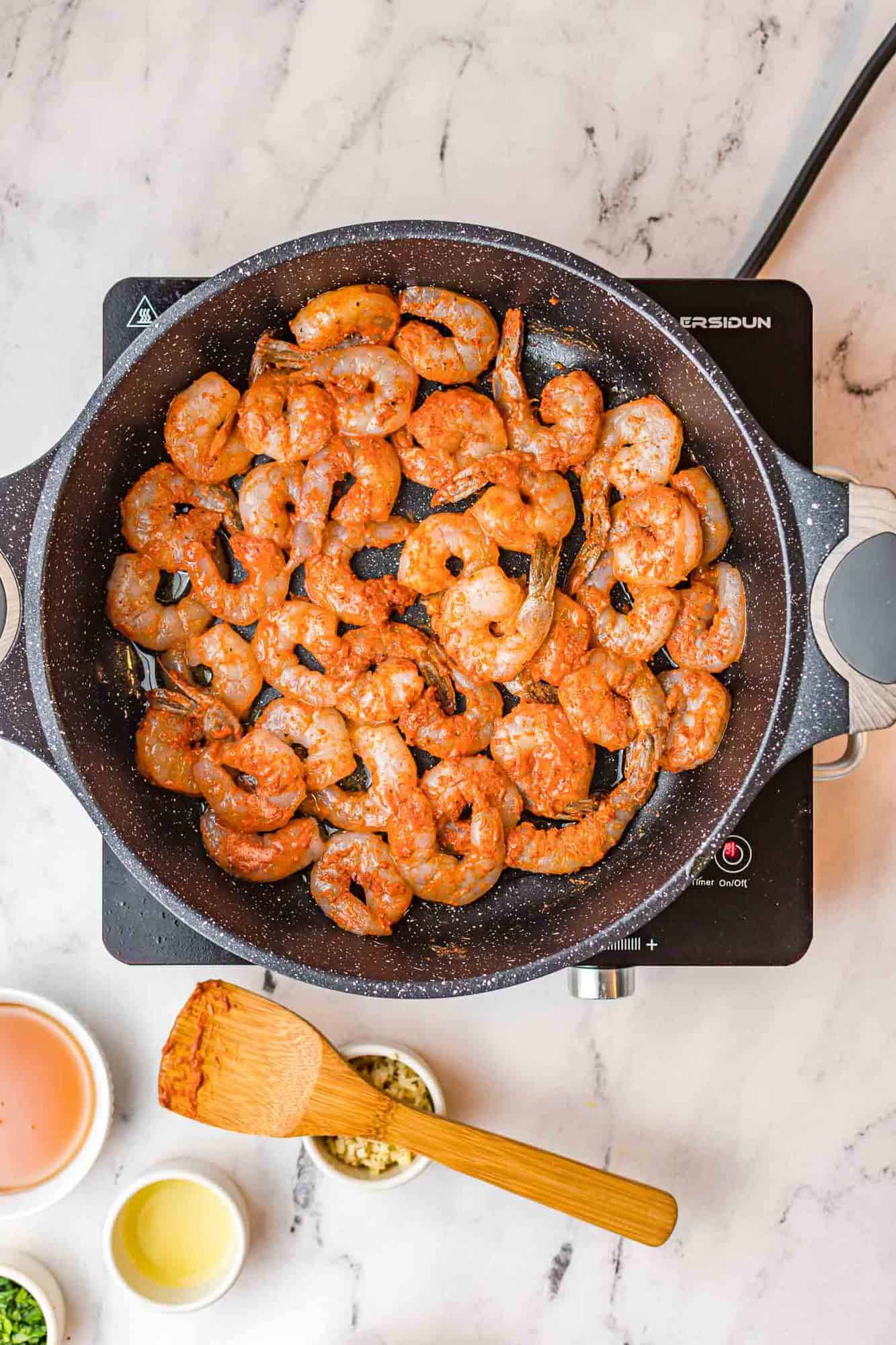 Seasoned shrimp in a skillet.