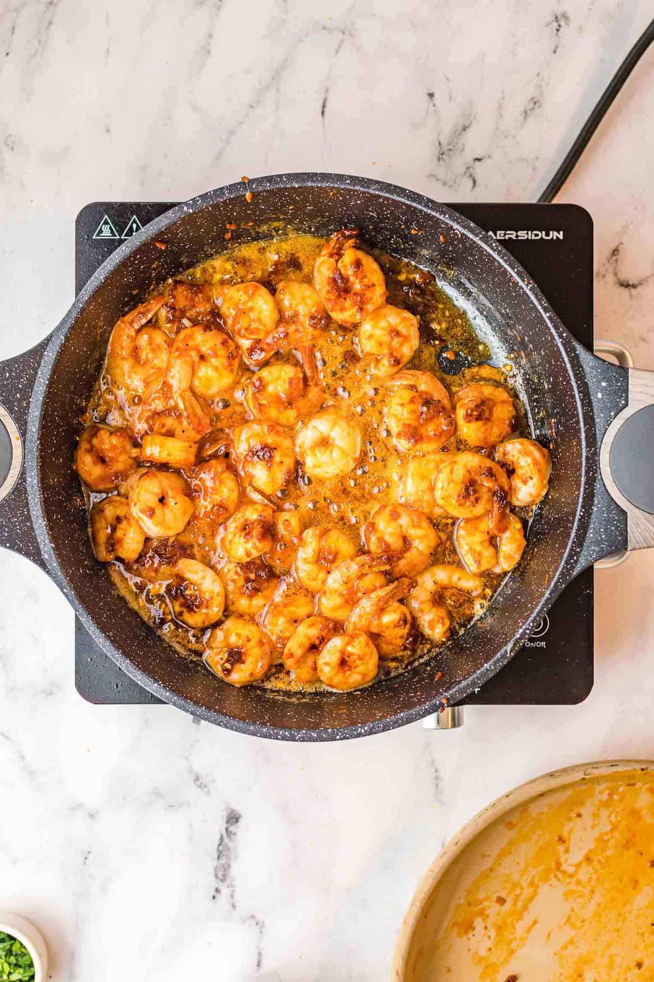 Cooked shrimp in a skillet.